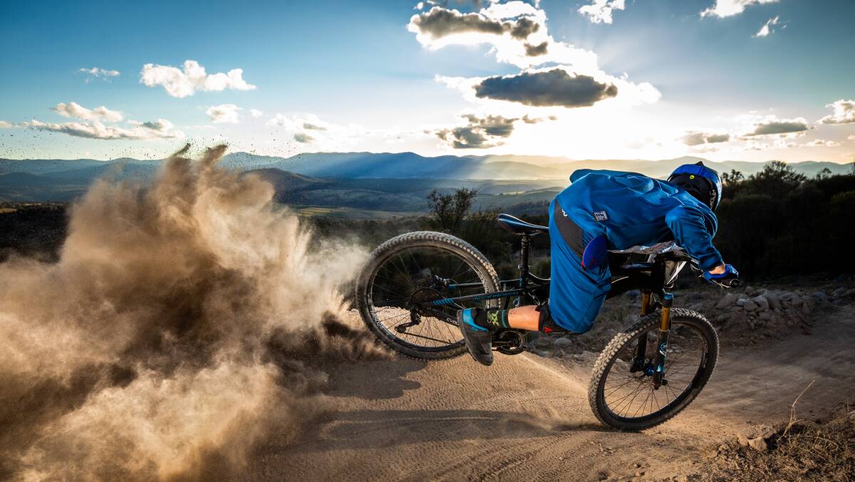 Dusty outlook: Sam Poulton kicks up dust at Mt Stromlo in Canberra as the sun sets. Photo: Richard McGibbon