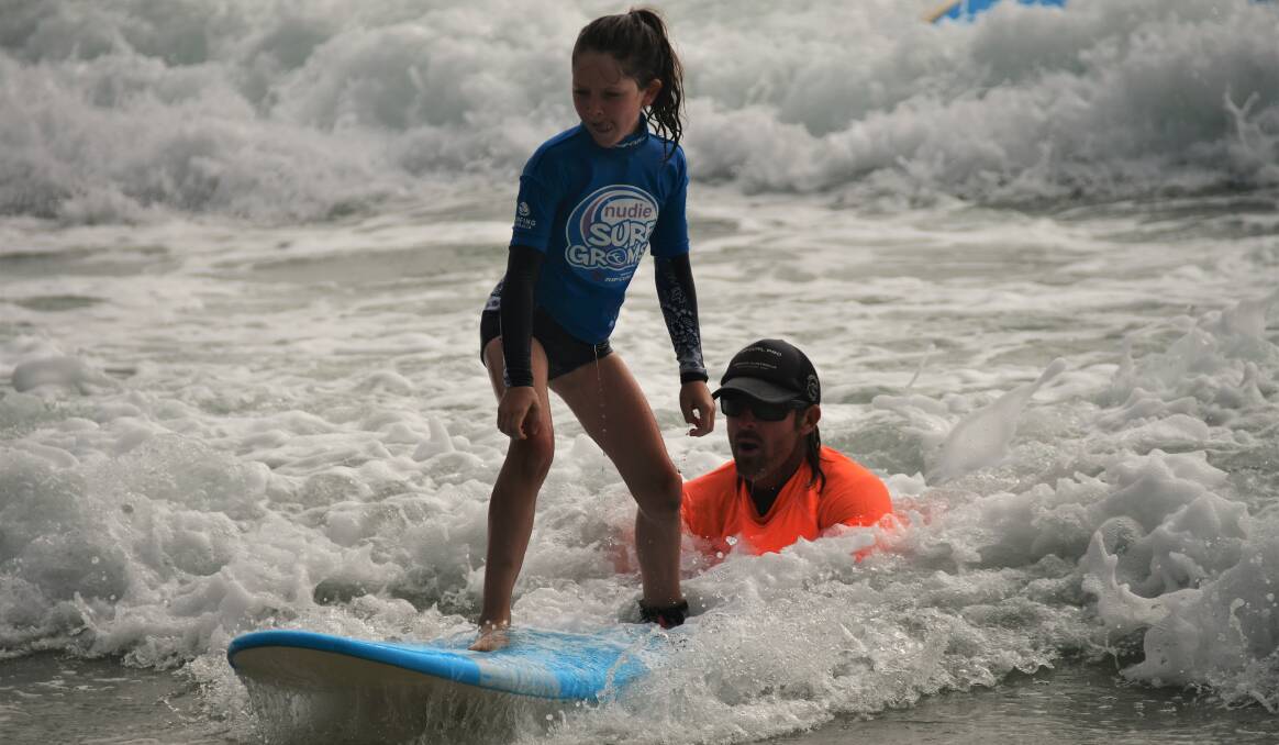 Up and away: Pippa Hudson learns to surf at the SurfGroms lesson on December 1. Photo: Paul Jobber