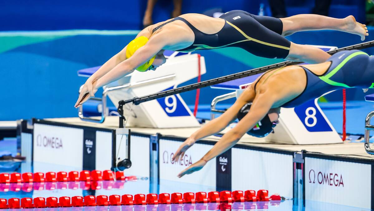 DIVING OFF THE BLOCK: Paige Leonhardt (wearing yellow cap) started swimming in 2012 to help with her rehabilitation after a car crash. Photo: Australian Paralympic Committee