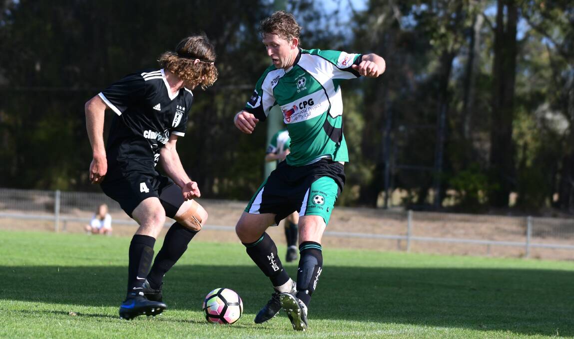 Teething problems: Port United's Matt Broderick takes on a Wallis Lake defender in last year's FMNC grand final. Wallis Lake have withdrawn from the new Coastal Premier League due to kick off next season.