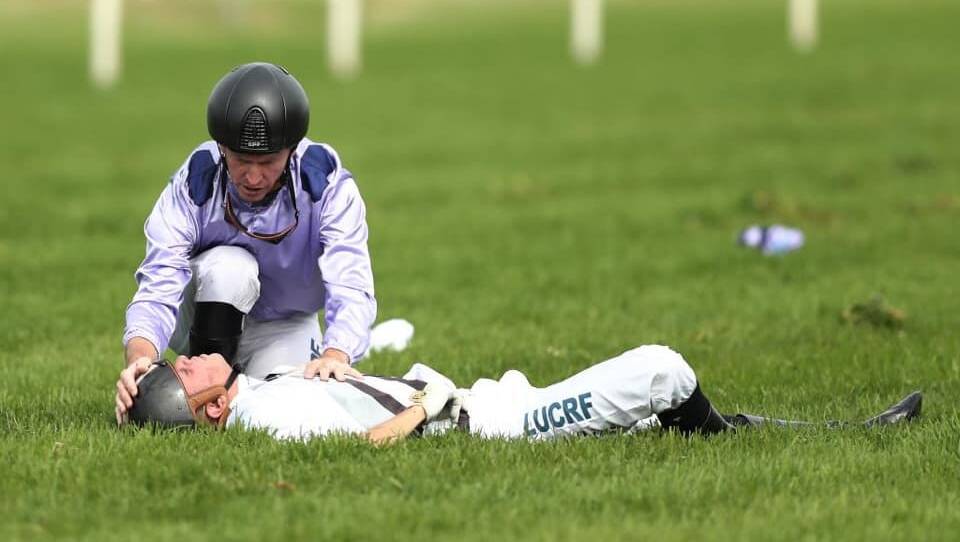 Mateship: Jockey Glyn Schofield attends to Andrew Adkins after a horror fall at the finish line, during the Kings Of Sydney Sport Mile during The Championships. Photo: Facebook