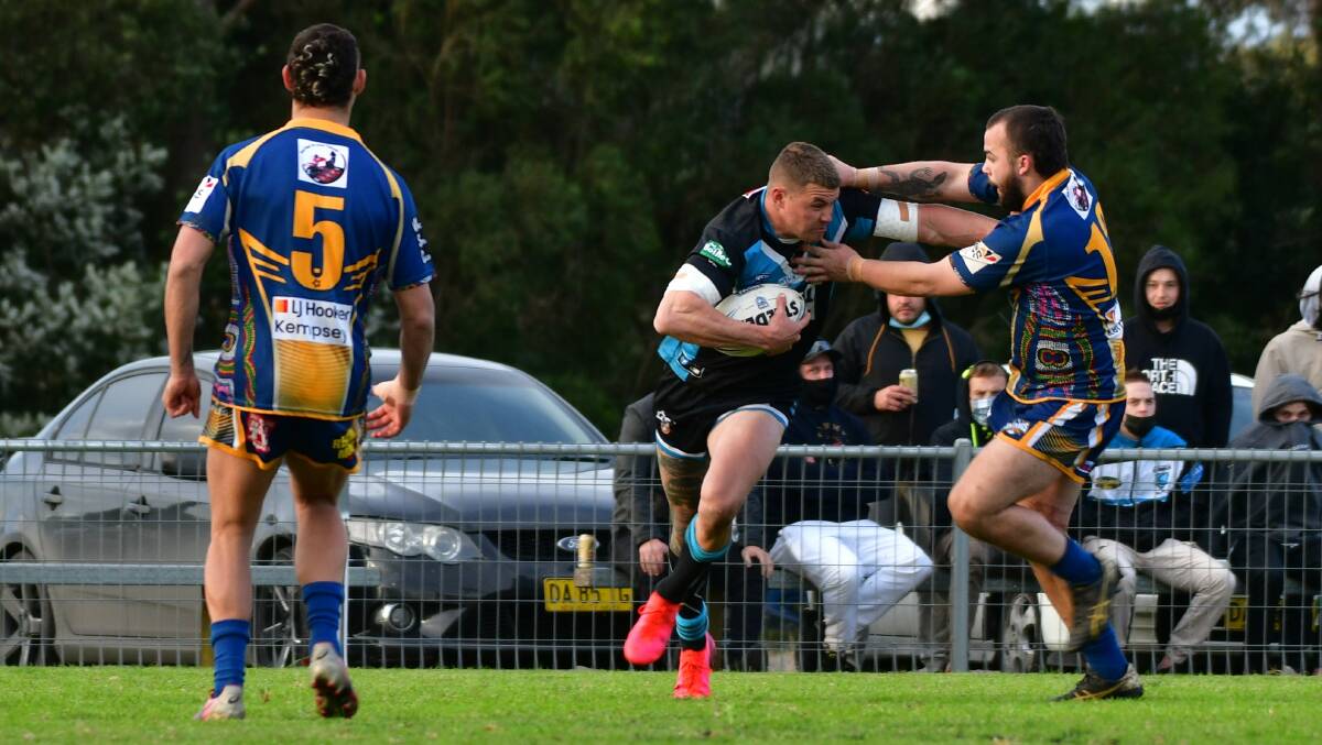 Push and shove: Dylan Adams pushes away from his Macleay Valley opponent. Photo: Paul Jobber