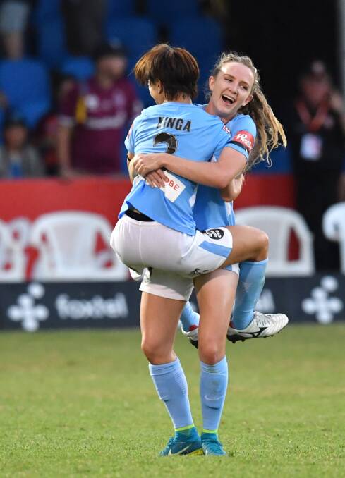 CELEBRATIONS: Yukari Kinga (left) and Rhali Dobson (right) embrace after winning the W-League semi-final at Perry Park in Brisbane. Photo: AAP Image/Darren England
