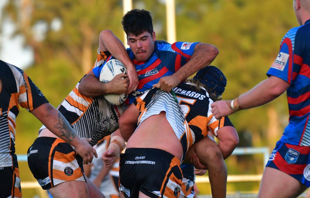 Down you go: Tony Thompson takes on the Wingham defence in the opening round of Group 3 on Saturday. Photo: Paul Jobber