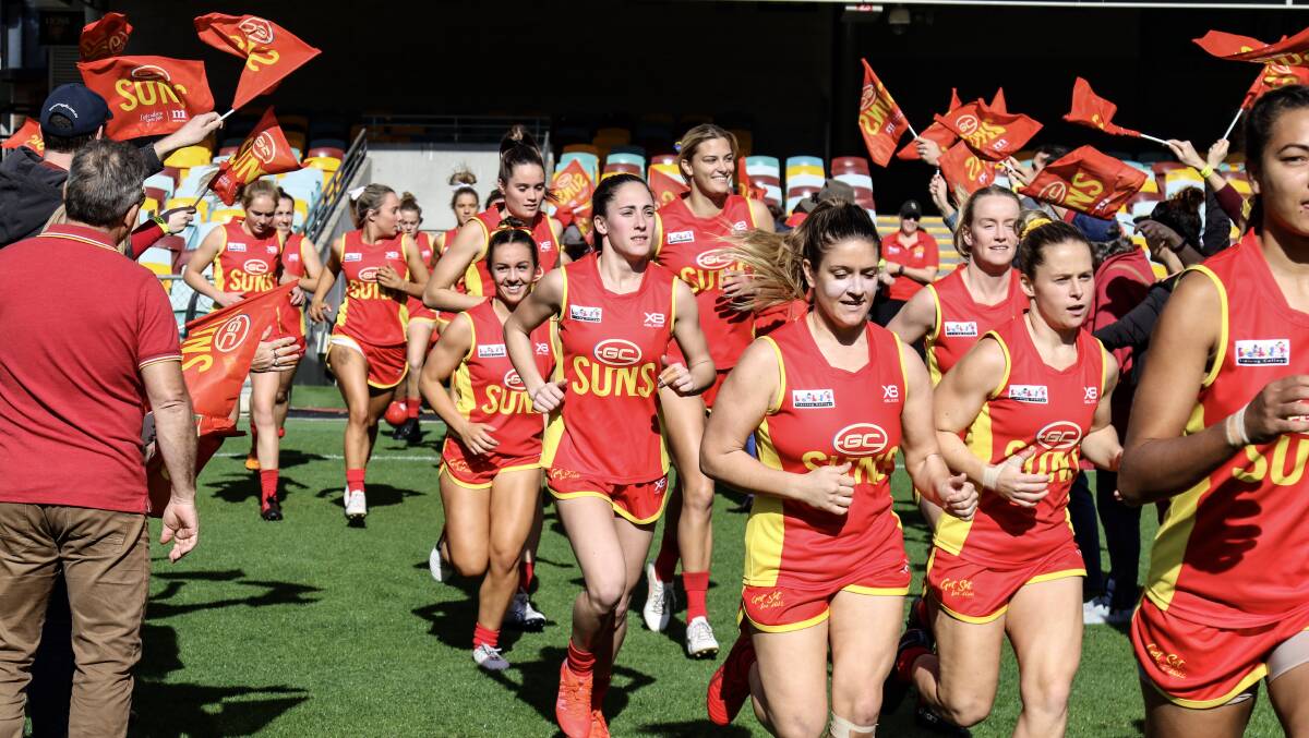 Away we go: Cambridge McCormick runs onto the Gabba with her Gold Coast Suns teammates. Photo: supplied
