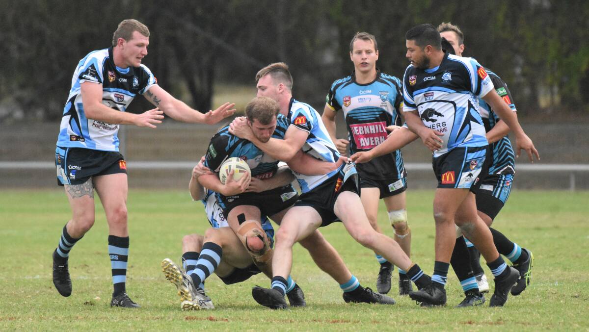 Protect the head: Mitch Smith takes the ball forward for Port Sharks in their derby clash with Port City in 2019.