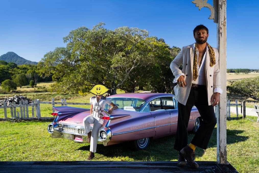 PARADISE: Dope Lemon, aka Angus Stone, on his Byron Bay hinterland property with the restored 1960 rose pink Cadillac which he plans to give away to a lucky fan.