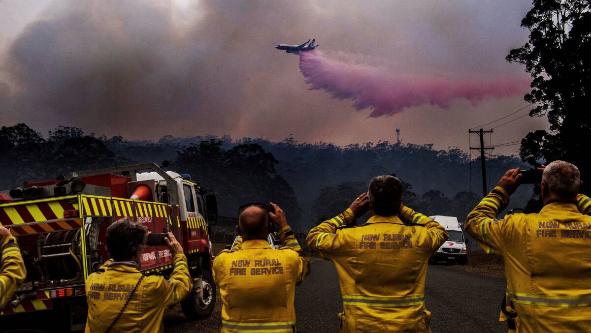 Ready, set, snap: Nick Moir captured this wonderful image as fire retardent is spread across the fireground on Wednesday.