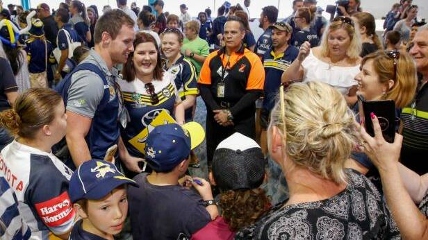 Tropical hero: Michael Morgan is swamped by supporters after the Cowboys arrive at Townsville Airport. Photo: AAP
