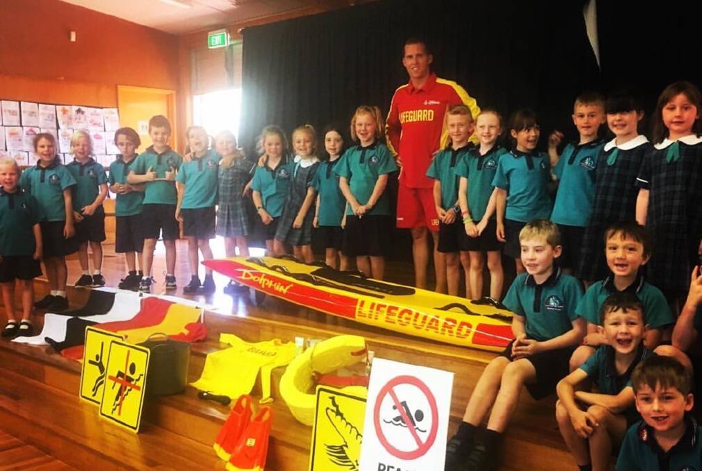 James Turnham with Tacking Point Public School students after a surf safety presentation. Photo: supplied