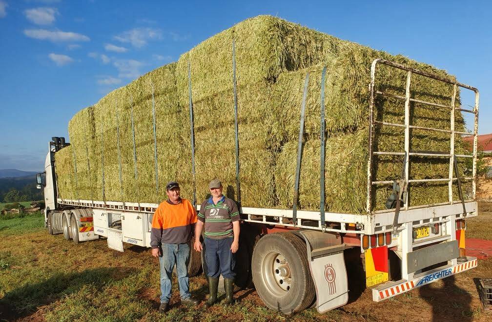 FIRST DELIVERY: Brombin farmers Luke Cleary and Michael Hillard with hay from the Mount Hope area near Cobar. Photo: Leo Cleary
