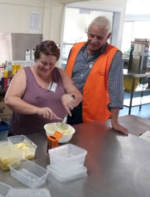 Janette Campbell preparing food for hungry BlazeAid volunteer Rhode Stevens at the Wauchope Showground. Photo: supplied