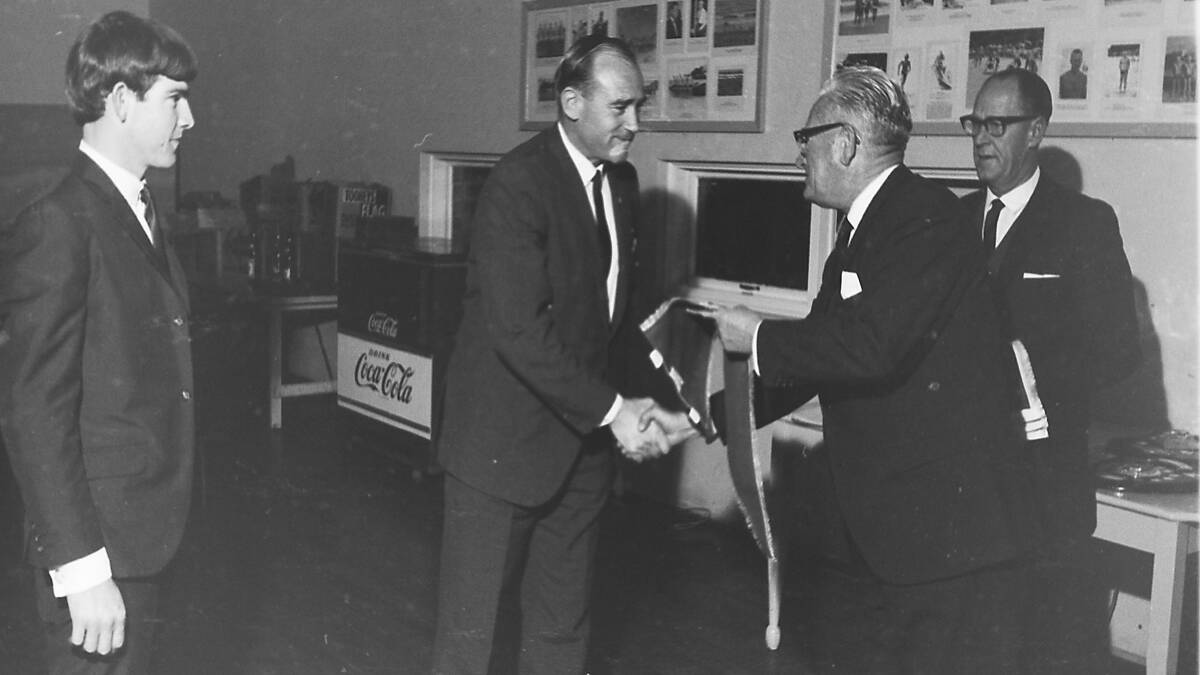 Deputy president of state SLSA Ern Lawler presents a branch Honour Pennant to John Dingle of Port Macquarie. Mr. Dingle was awarded for service to Nippers lifesaving.  