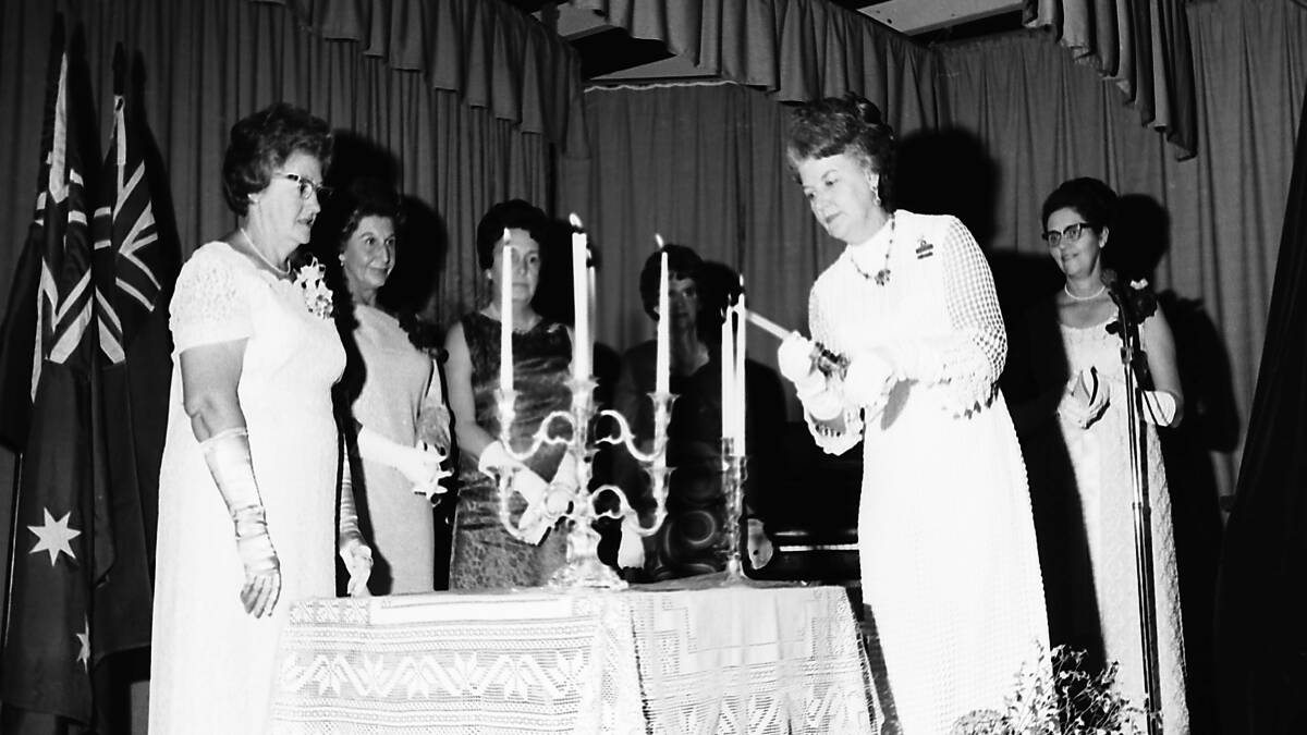 President of Port Macquarie Club, Mrs Dorothy Gentle, kindles the flame of Quota, 1969.
