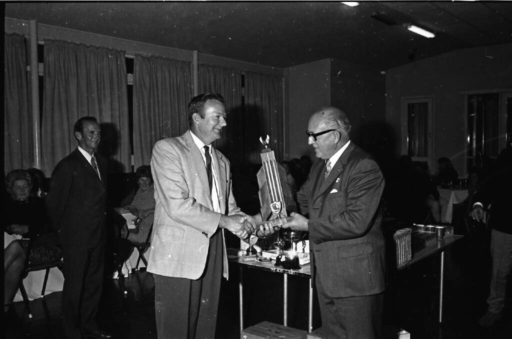 Congratulations: Ald C.C. Adams (at right) presents Arkie Walsh with the V-Ess championship award at the Sailing Club presentation night, 1971.