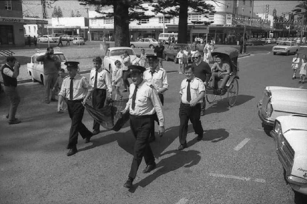 Quite a 'feet': Volunteer firemen pull the fundraising rickshaw the last few steps to their Port Macquarie destination, 1970.