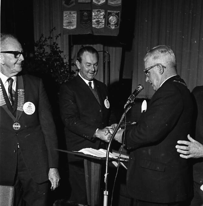 Well done: Mayor Ald D.S. Kennedy presents a spoon to Rotarian Bob Plain for his 100 per cent attendance record over the past year, 1971.