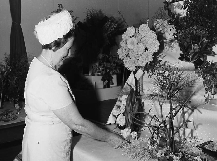 Pretty petals :Popular florist Mrs S Hewens judging entries at the Dahlia Show, 1971.