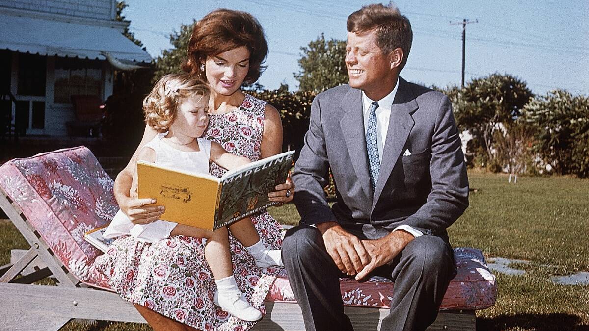 Jacqueline Kennedy, with her husband Senator John F Kennedy, reads to her daughter Caroline from a book. Picture: Getty Images