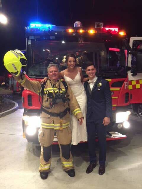 CHEERS: Port Macquarie FRNSW officer with the bride and groom Emily Robinson and Kyle Rathbones. Photo: Tahnee Borg.
