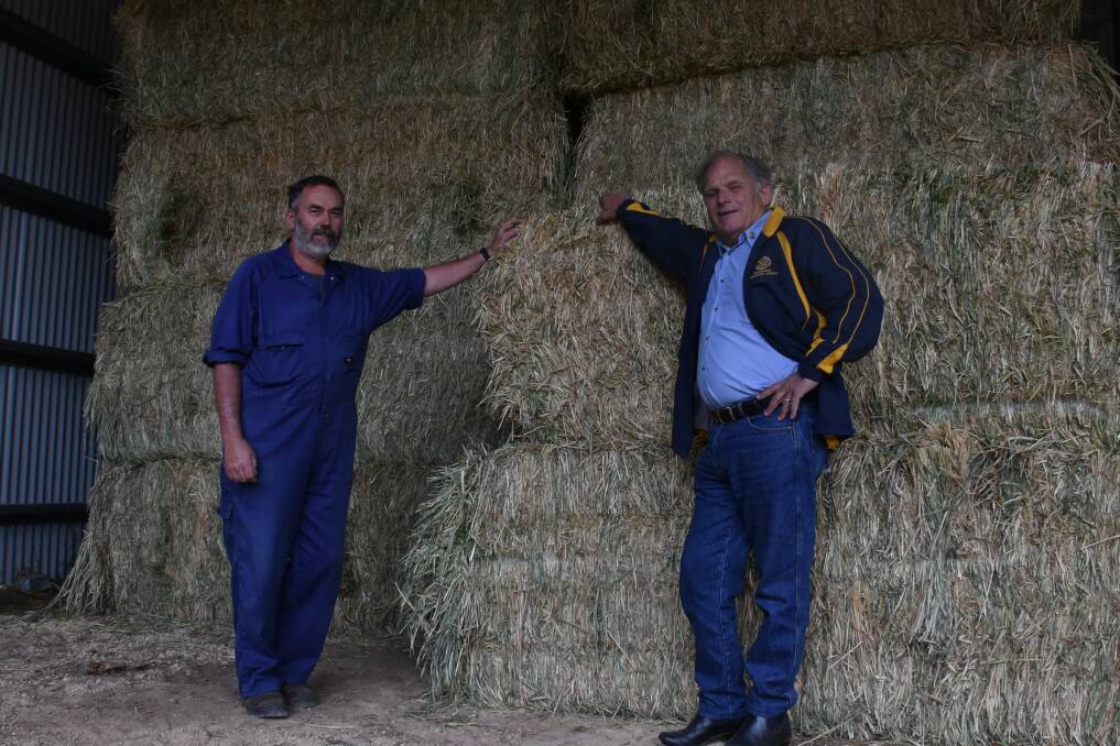 LIFELINE: Hastings dairy farmer Bob Baker and Wauchope Rotary's Reg Pierce with the first of the hay. PHOTO: Laura Telford.