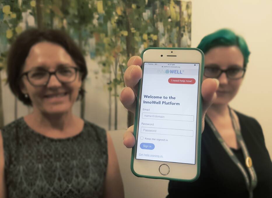 ONLINE HELP: Jenny Sinclair and Lisa Hogan from headspace Port Macquarie with the welcome screen people will be directed to when they take part in the trial.