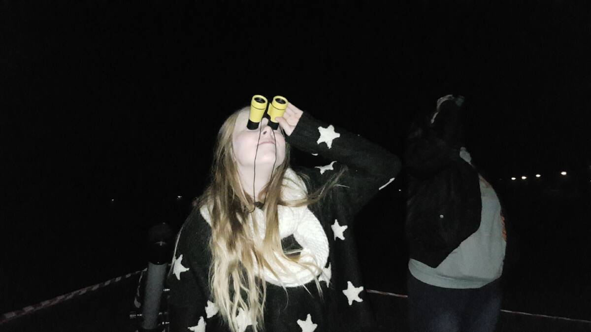 STARGAZING: Ashleigh Kiem looking at the moon and taking part in the world record attempt. Photo: Laura Telford.