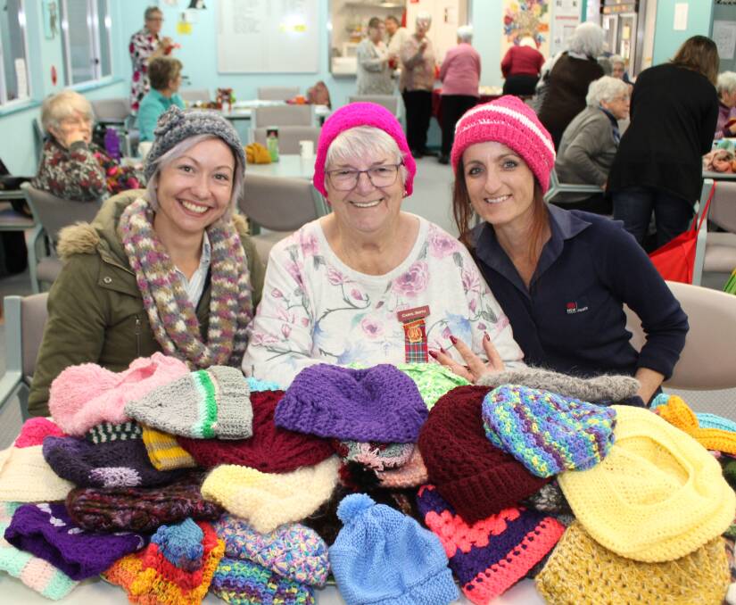 UHA President Carol Smith with a mountain of colourful beanies created by her
volunteers for the Reclaim the Night March in October. She is pictured with educators from the MNCLHD’s Domestic Violence Prevention team, Renee Bell and Tia Bailey. Photo: supplied. 