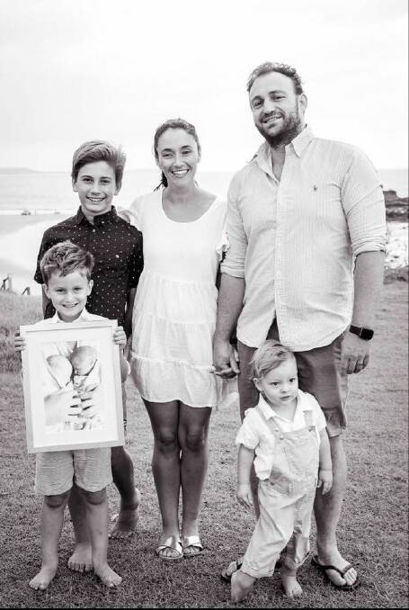 Family love: Jacqueline and Jonathon Hoy with their boys Lachlan, Edward (holding a photo of twins William and Henry) and Alexander. Photo: Kirsty Fikkers Photography.