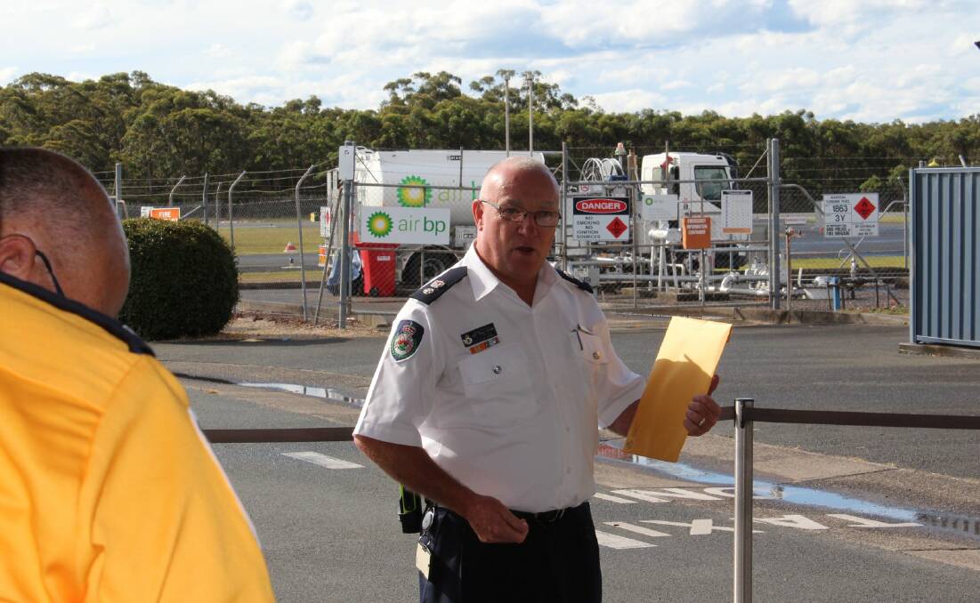 Good luck: District Manager Kam Baker addressing the RFS volunteers prior to departing Port Macquarie Airport for Queensland's Hervey Bay on Wednesday evening. Photo: NSW Rural Fire Service - Mid Coast District
