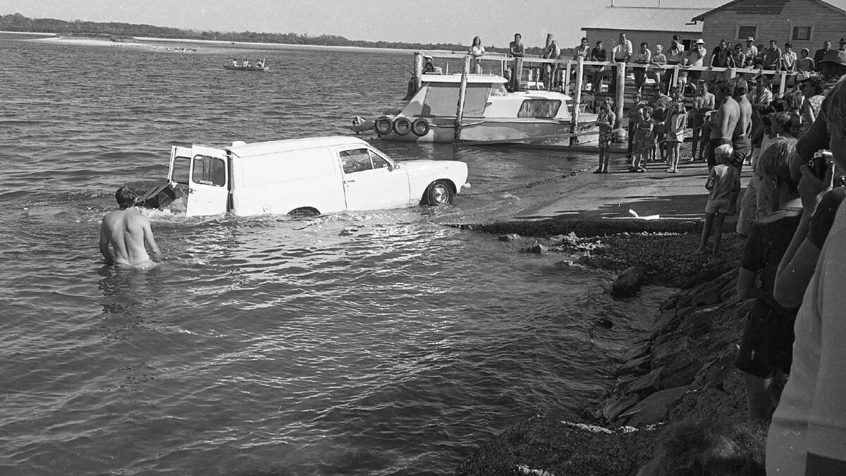 Ken Chapman watches on as the water-logged car belonging to Ken Little is towed from Kooloonbung Creek, 1972