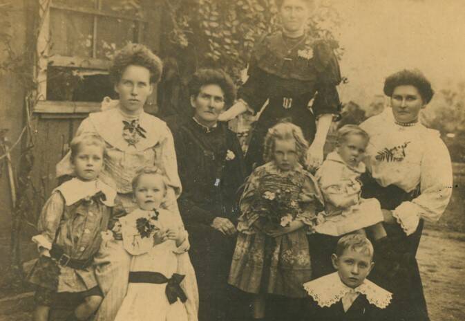Ellen Dunbar with her three daughters and grandchildren in front of the family home.