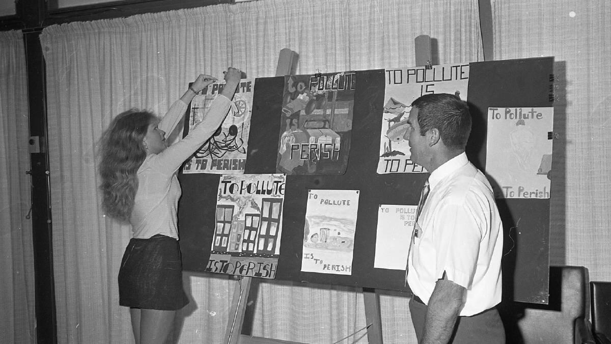 Dirk Kirby, Health Department official and organiser of Health Week, inspects some of the entries in the schools poster competition, 1971
