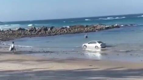 The driver drive his vehicle into the water at Shelly Beach as baffled onlookers watched on. Image: James Godfrey.