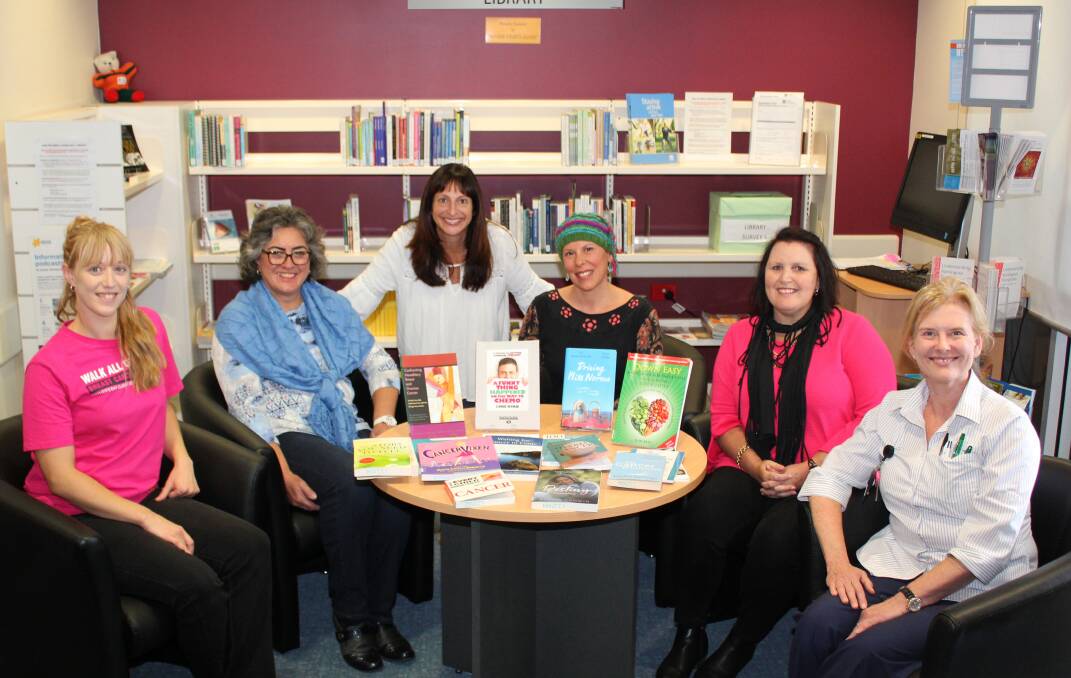 Kylie Bulmer, Mid North Coast Local Health District Librarian Helen Miles, Carmen Abi-Saab, The Pink Girls’ Magalie Lameloise and Tracy Stone with Nursing Unit Manager Jenny Baroutis and some of the books donated to the MNCCI in support of cancer patients.