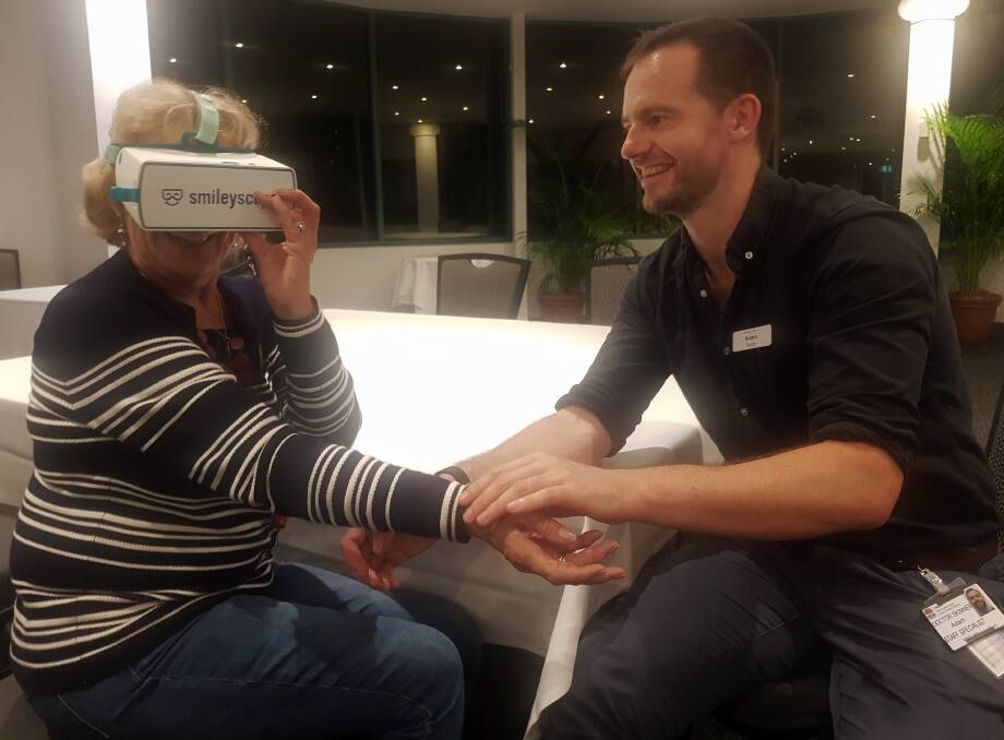 Rotarian Joan Gilson tries out the Smileyscope with Dr Adam Skinner.