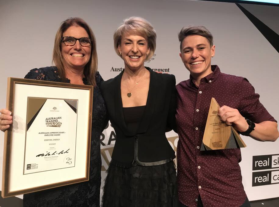 Essential Energys Manager Learning and Development, Lara Rich and Lismore Powerline Worker Courtney Nelson accepting the award from Federal Minister for Employment, Skills, Small and Family Business Michaelia Cash.