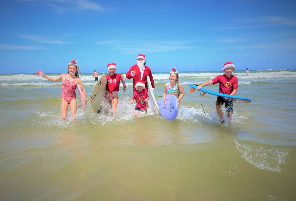 Brad Waite, Bodhi Waite, Archer Waite, Summer Waite, Annabelle Broderick and Grace Broderick were back in the waves for the annual Surfing Santas paddle out at Rainbow Beach, Bonny Hills. Photo: Tracey Fairhurst