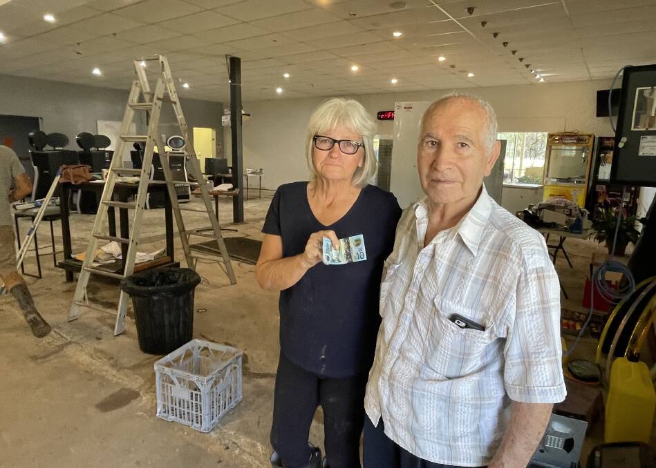 Please help: Pam McArdle of Telegraph Point Sports and Recreation Club with local resident Mario Vitiello. Mario donated $10 to help the community flood effort and has baked his delicious lasagnes to keep spirits up.