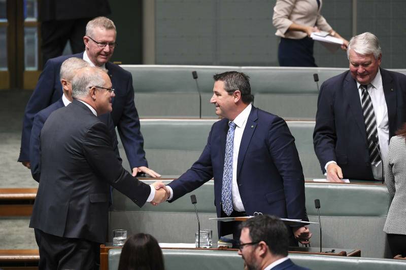 The Member for Cowper Pat Conaghan (right) is congratulated by Australian Prime Minister Scott Morrison after delivering his maiden speech in the House of Representatives at Parliament House in Canberra, Wednesday, 24 July, 2019. (AAP Image/Lukas Coch)
