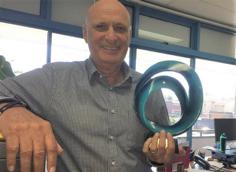 It was personal: Ironman organising committee chair Mike Reid holding the Wayne Jackson Community Service Award he received at the recent Port Macquarie Business Awards.