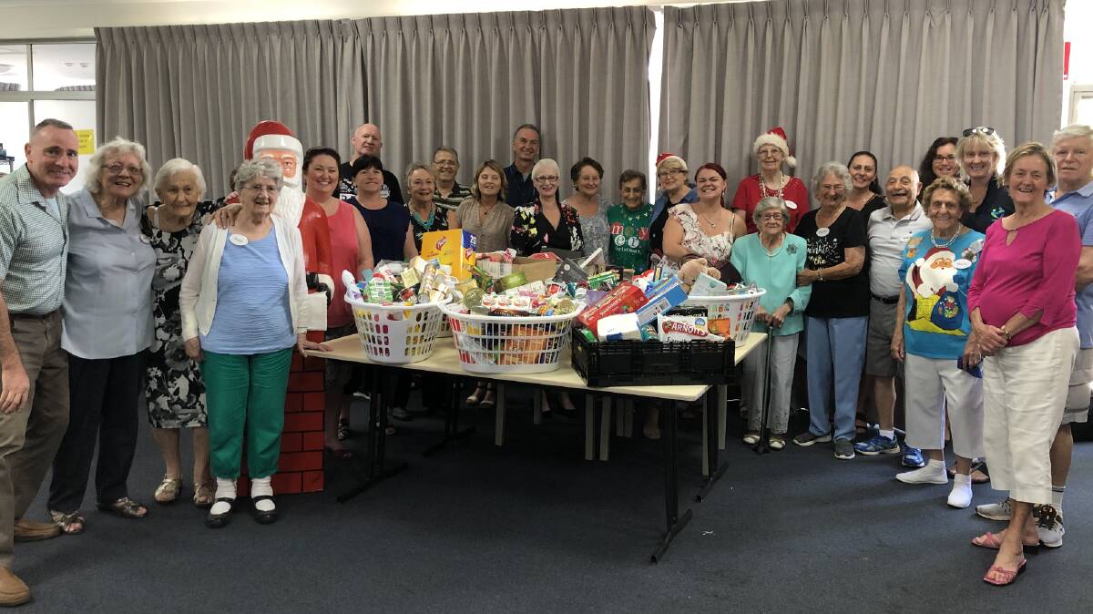 Team effort: clients living with dementia, staff and volunteers at Omnicare Alliance’s Morton St day centre had their hands full filling Christmas hampers for local causes.