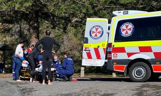 Mark Rapley watches on as emergency services treat his wife Chantelle at Shelly Beach following the shark attack. Photo: ALS Lifeguards.
