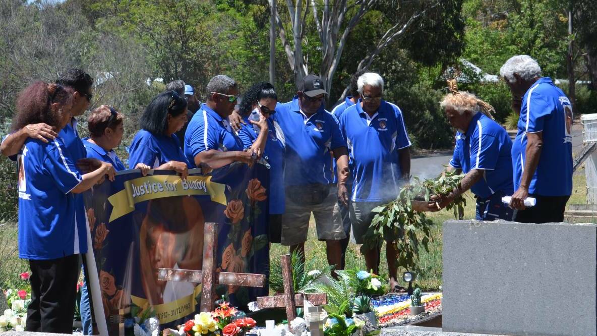 SPIRITUAL GUIDANCE: Lewis 'Buddy' Kelly's siblings gather around his grave during the smoking ceremony. Photo:Vanessa Arundale.