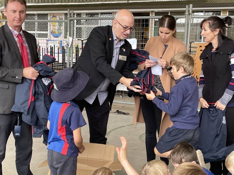 Northbridge Rotarian Kevin Tattrie hands out the new winter jackets to students in year 2.