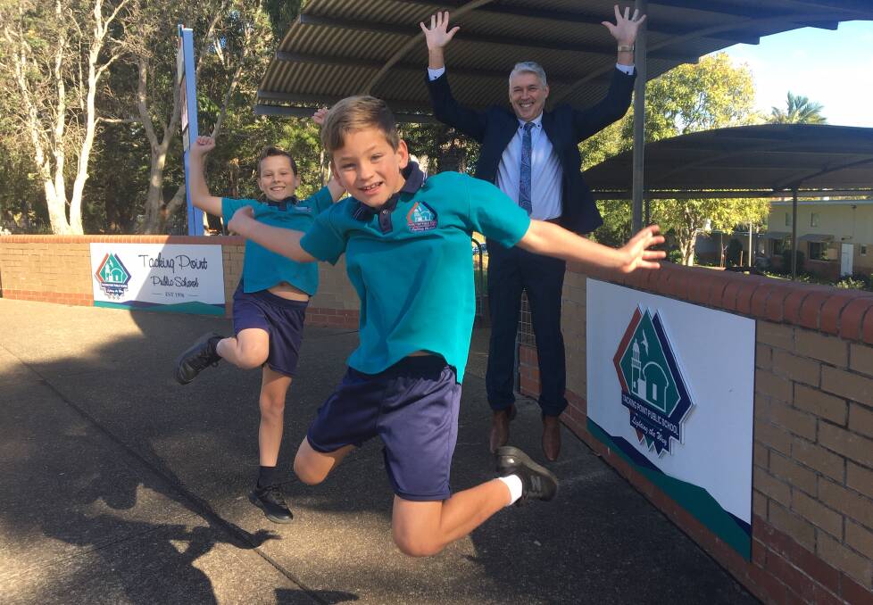 Tacking Point Public School year 5 students Albie Watson and Wil Clark jump for joy with principal Phil Harris because school is back.