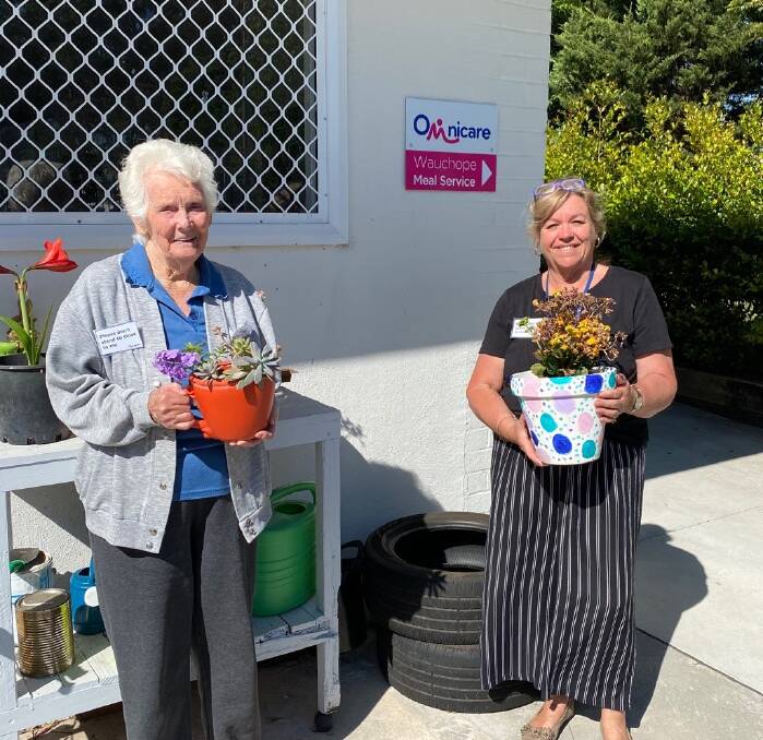 Omnicare Social Support Group regular Bess Dubois and SSG centre coordinator Keren Longbottom, both holding plant pots decorated by clients.