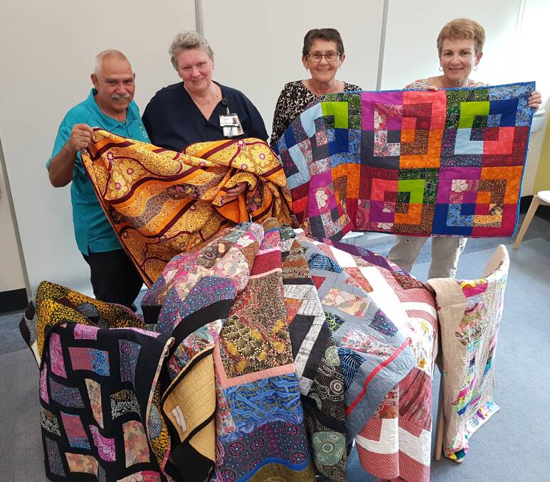 Uncle Bill O’Brien, Palliative Care nurse Lynette Barker, Marilyn O’Brien and quilter Erica Taig with some of the beautiful quilts donated to Palliative Care Unit patients.