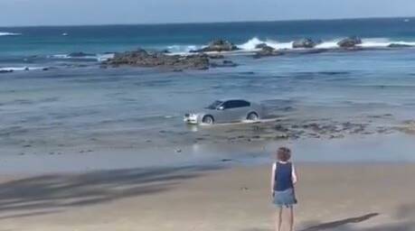 The driver drive his vehicle into the water at Shelly Beach as baffled onlookers watched on. Image: James Godfrey