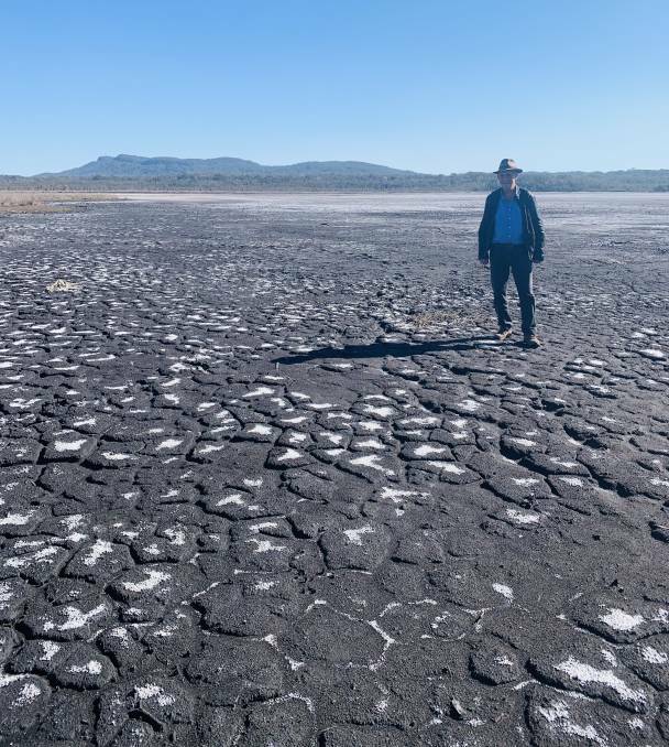 On the ground: Environmental scientist Colin Creigton inspects a dried up section of Lake Cathie.